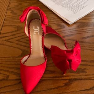 Red satin pumps with accent bow. Brand new